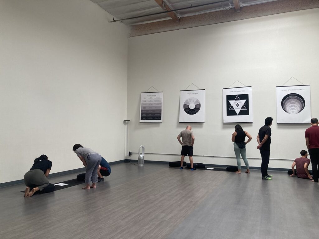 Students studying framework posters during Cinthia Durán's Movement Technologies session at the Community Yoga Center
