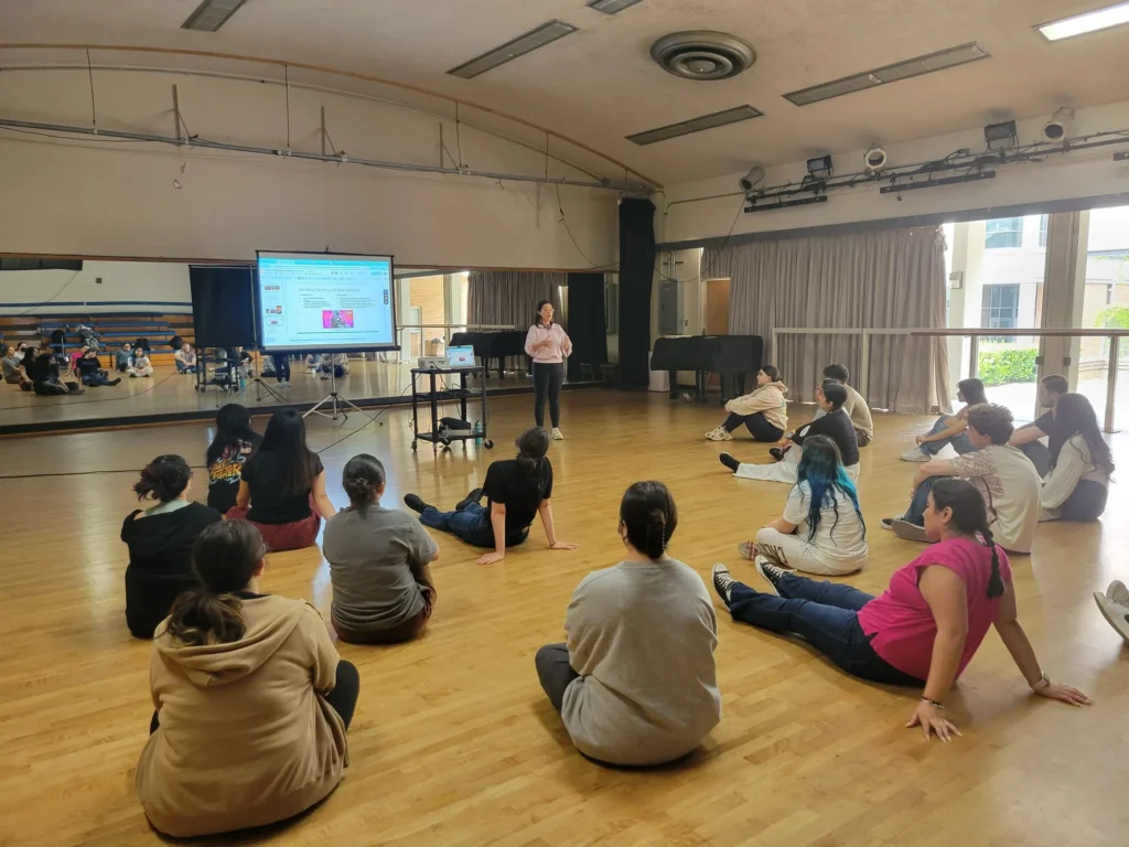 Wide view of a dance-studio presentation with an open doorway to the outside