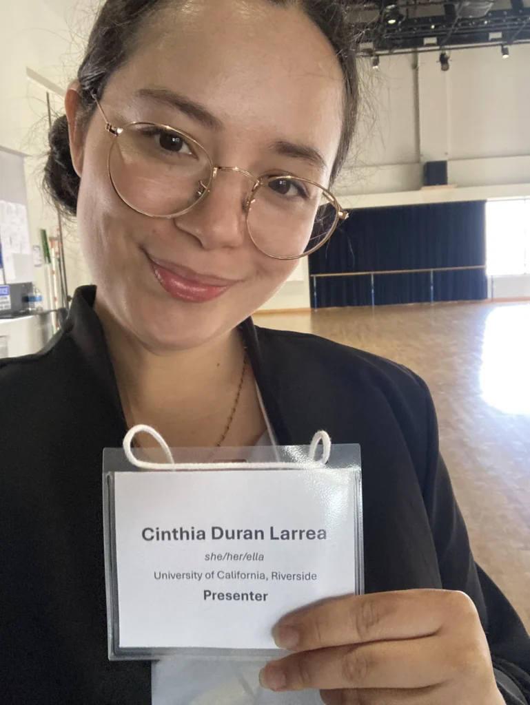 Cinthia Durán holding her presenter badge, University of California, Riverside