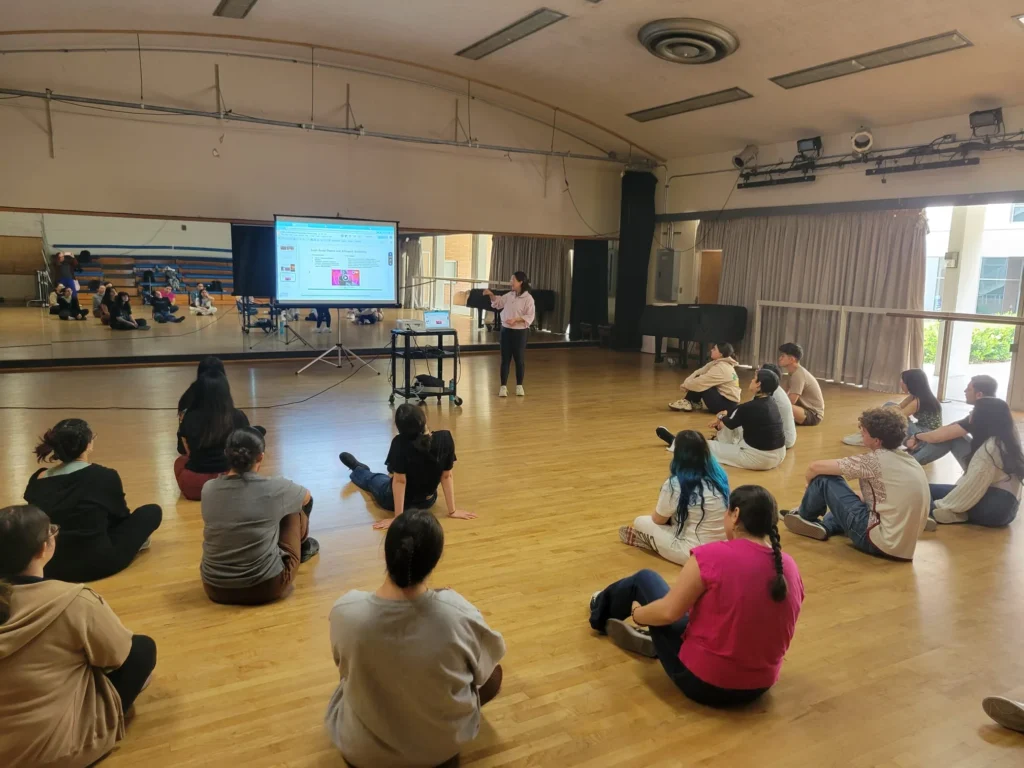 Dance-studio presentation seen from across the room, piano at right