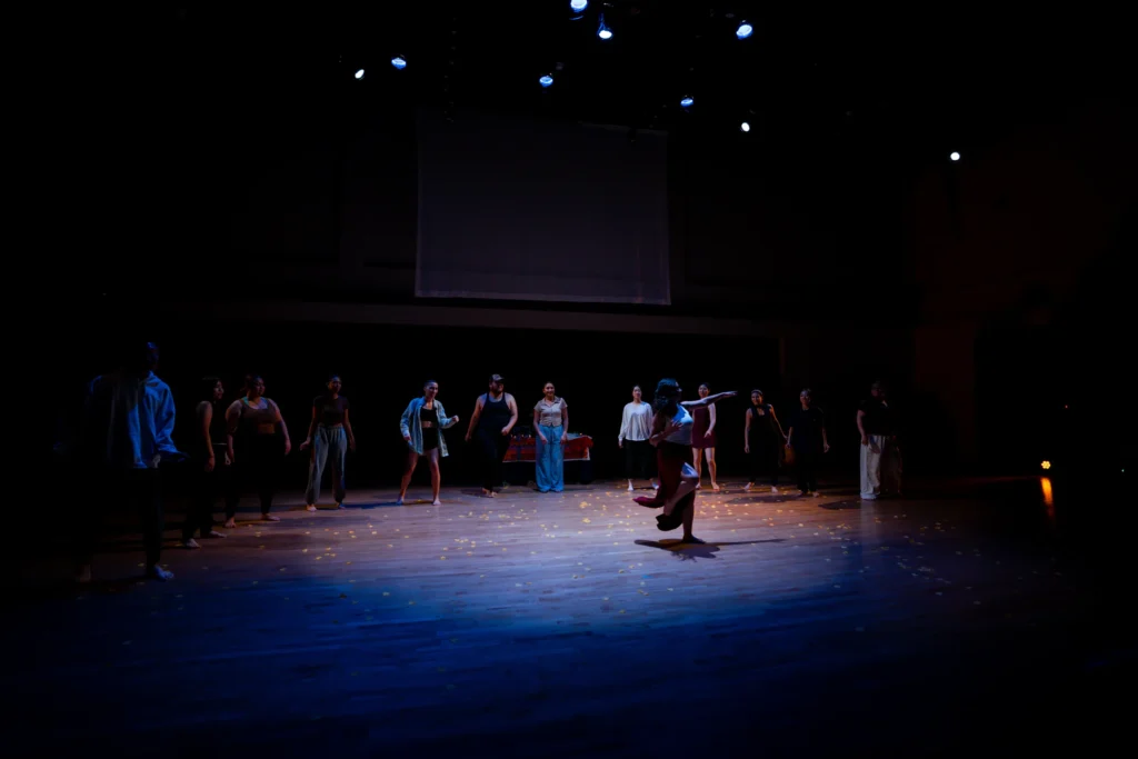Ritwal — the ensemble ringing a soloist amid scattered petals, UC Riverside Department of Dance, Spring Forward 2023